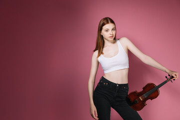 Girl in black plays violin on pink background