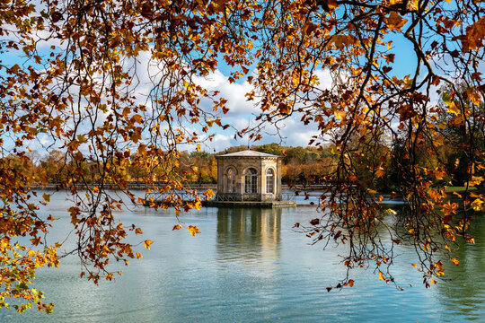 Fontainebleau, France: Pavilion in the middle of the Carp Pond with the royal castle of Fontainebleau in the background. Shot in autumn on a cloudy day.