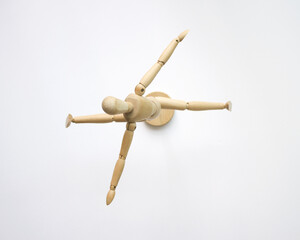 A wooden doll is dancing ballet doing splits and raising its hand up. Isolated on white background.
