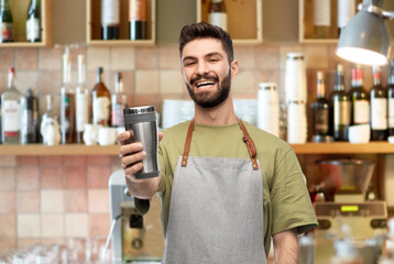 people, profession and job concept - happy smiling waiter in apron holding tumbler or takeaway...