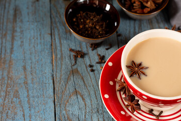 Masala tea. Indian masala tea in a cup with spices on a blue background. Traditional Indian drink. Tea or coffee with milk