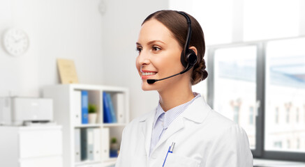 medicine, profession and healthcare concept - happy smiling female doctor with headset over hospital background