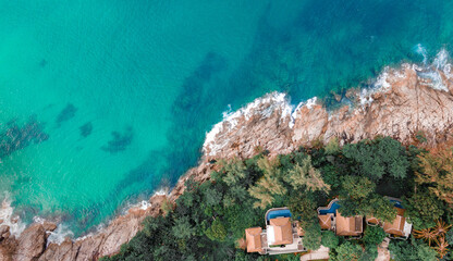 Panoramic view over rocks landscape and luxury pool villa resort facing to the ocean at Naithon Beach, Phuket, Thailand. Drone taken.