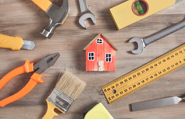 Work tools with a wooden house model.
