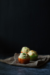 Ham, cheese and broad beans muffin. Dark background.