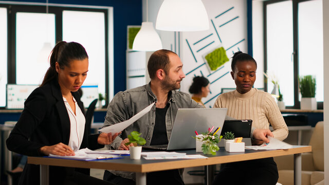 Team of diverse startup company colleague entrepreneur meeting in professional workplace, brifing and sharing ideas over financial strategy management. Multiracial business people working together.