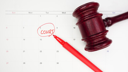 The words Court written and judge's gavel on the white calendar to remind you of an important trial...