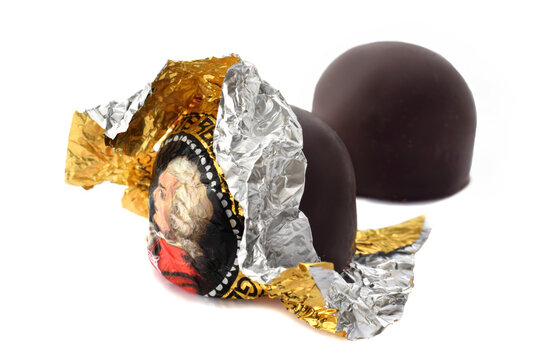Mozartkugel closed up wrapped into foil with portrait of Mozart Editorial illustrative image of chocolate pralines isolated on white.