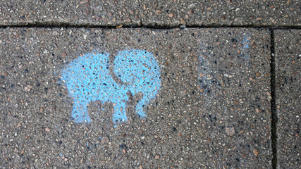 Blue elephant stencil on a footpath or sidewalk