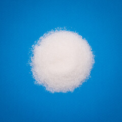 Obraz na płótnie Canvas Heap of sugar on blue background