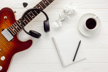 Desk of musician for songwriter work set with headphones and guitar