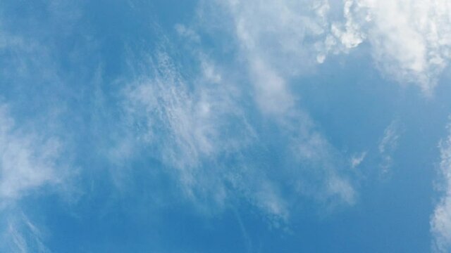 Time lapse clip of white fluffy clouds over blue sky, Flight over clouds, loop-able, cloudscape, day, sunny beautiful clean weather, soft colour skies with cloudscape.