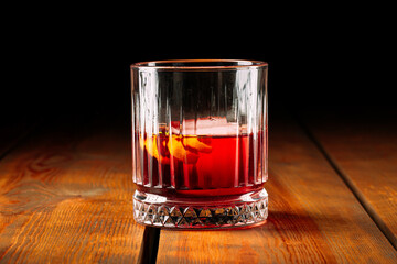 Side view on negroni cocktail in old fashioned glass on the wooden table