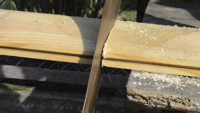The process of cutting wooden board by vintage hacksaw or handsaw. Video of the carpenter work
