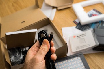 POV male hand unboxing unpacking new USB-C power cable