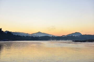 An early morning view with beautiful colorful lights Before sunrise At the Fisherman Village near Mon Market at Mon Bridge, Sangkhlaburi District, Kanchanaburi Province, Thailand