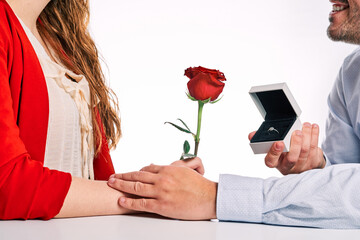 Man giving engagement ring to his partner and a red rose. Concept of Valentine's Day, couple in love and marriage proposal.