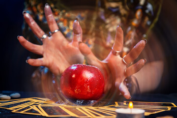 A fortune teller conjures a red apple lying on the Tarot cards. A magical aura emanates from the...