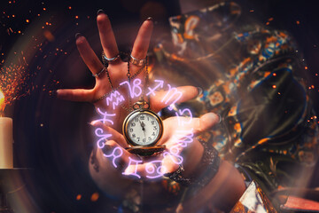 The fortune teller holds a watch on a chain in her hands and conjures over it. A luminous zodiac...