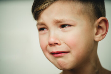 portrait of a crying boy on a white background close-up