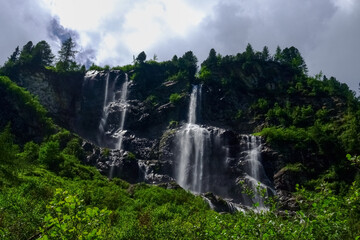 beautiful high waterfalls over rocks on a mountain