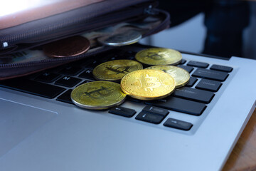 Close up golden Bitcoin in brown leather wallet on notebook, busines concept.