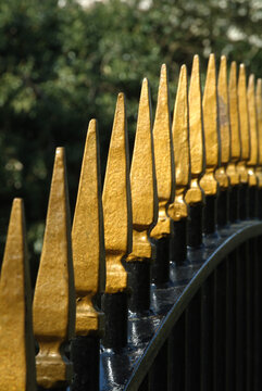 Close up of gold paint finials on iron railings.