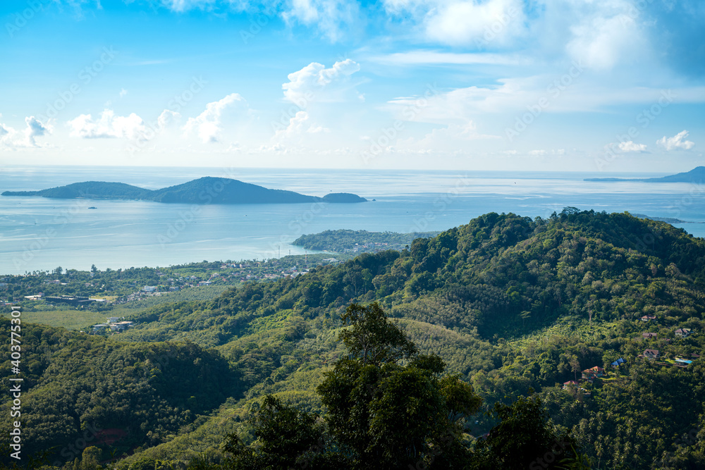 Poster The landscape of the mountain ridge of Phuket and the Adaman Sea against the background of a blue sky with clouds.