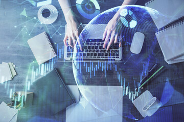 Multi exposure of woman hands working on computer and forex chart hologram drawing. Top View. Financial analysis concept.
