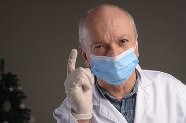  Senior medical doctor in protective gloves and face mask over grey background