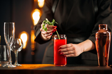 Woman making bloody mary cocktail garnished with celery