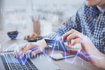 Double exposure of man hands holding a credit card and Forex graph drawing. Stock trading and digital fintech in Internet E-commerce concept.