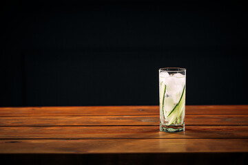Fresh gin tonic cocktail with rosemary and lime on the wooden table