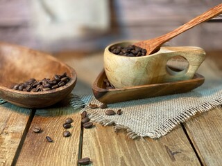 rozsypane Zairka kawy na stole drewnianym dębowym w naczyniach drewnianych i lnianej serwetce