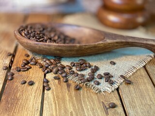 rozsypane Zairka kawy na stole drewnianym dębowym w naczyniach drewnianych i lnianej serwetce