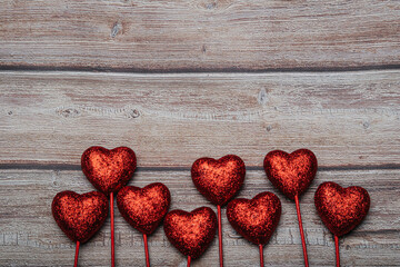 Valentine's day background with red hearts on an old dark wooden background. Copy space Vintage style.