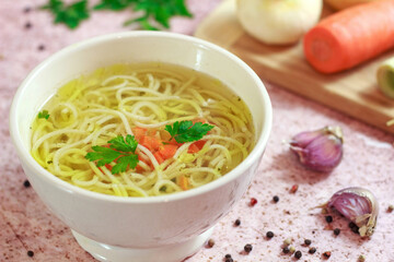 Tasty chicken broth with noodles and vegetables