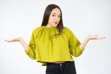 Portrait of a confused young casual girl shrugging shoulders isolated over white background