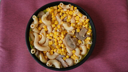 pasta, corn and mushrooms in a bowl for take-away