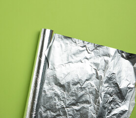 rolled sheet of foil on a green background, the corner is folded