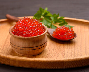 fresh grainy red chum salmon caviar in a wooden bowl