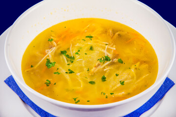 Hot chicken noodle soup with carrots and herbs