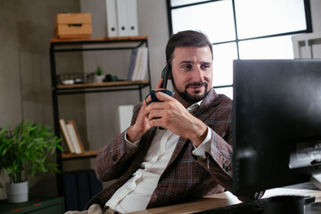 Businessman in office. Handsome man talking on phone at work..