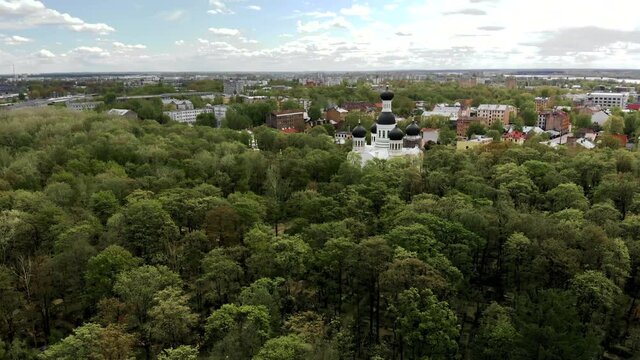 Scenic aerial flight towards beautiful old orthodox church of St. John the Forerunner in Riga with dome on reconstruction