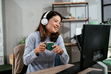 Businesswoman with headphones having video call on computer. Beautiful woman having meeting online.