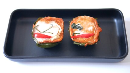 Steamed fish with curry paste and vegetable in bowl made from banana leaves isolated on white background, traditional Thai food