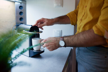 A young guy making a tea at the kitchen. Routine, morning