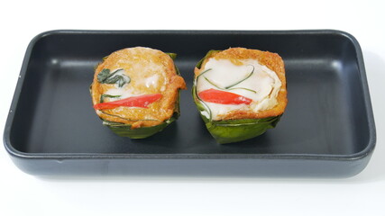 Steamed fish with curry paste and vegetable in bowl made from banana leaves isolated on white background, traditional Thai food