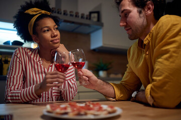 Lovely mixed couple relaxing and drinking wine together