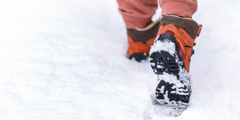 Walking or hiking on the snow with footprint on snow in the winter park.
